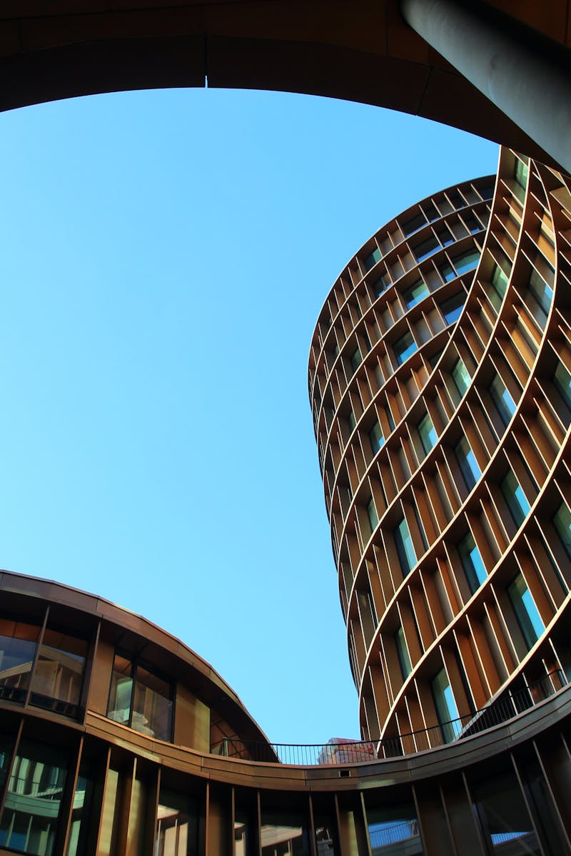 Innovative modern architecture showcasing curved glass structures against a clear blue sky.